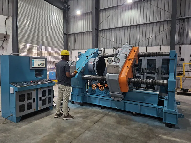 Technician operating a large hydraulic valve test bench from its control console
