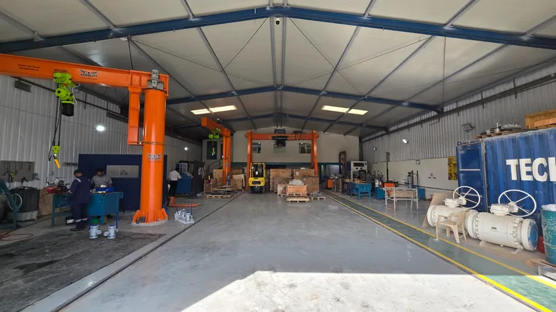 Inside the TMI workshop: jib cranes, a gantry crane, repair benches and large ball valves