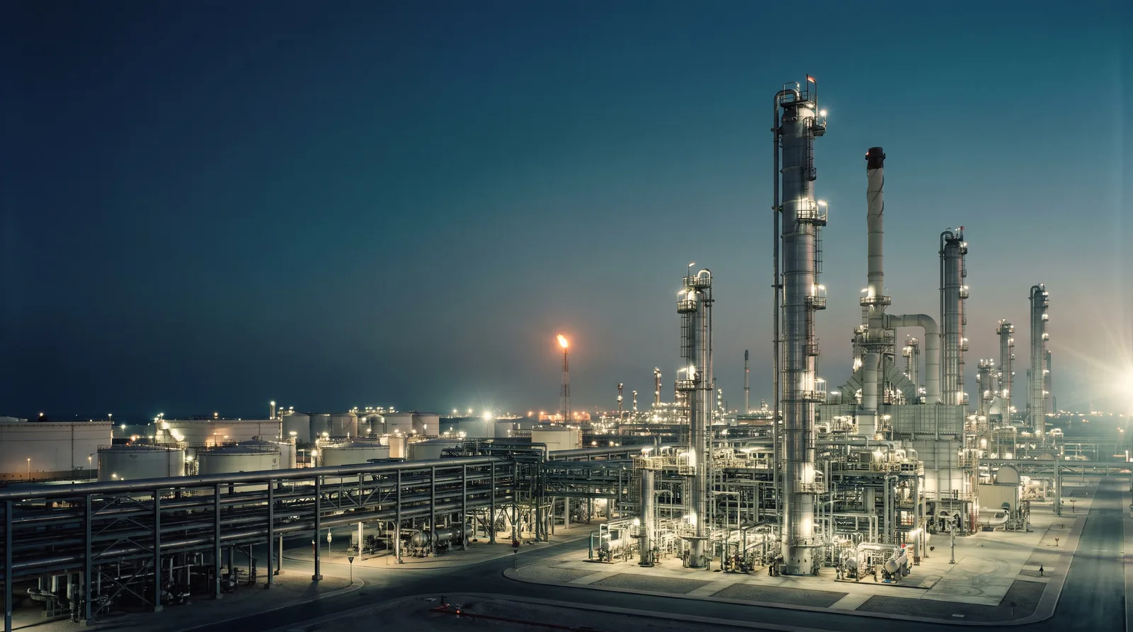 Refinery process units, pipe racks and storage tanks at dusk