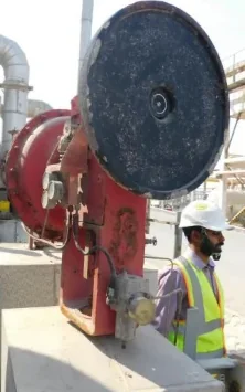 Worn diaphragm actuator before retrofit, with engineer alongside
